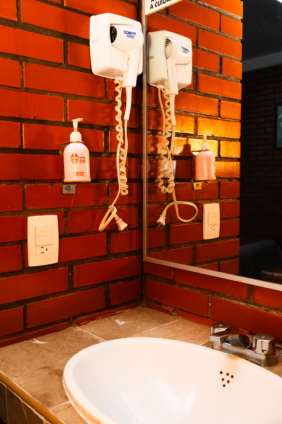 Lavabo junto a un muro de ladrillo