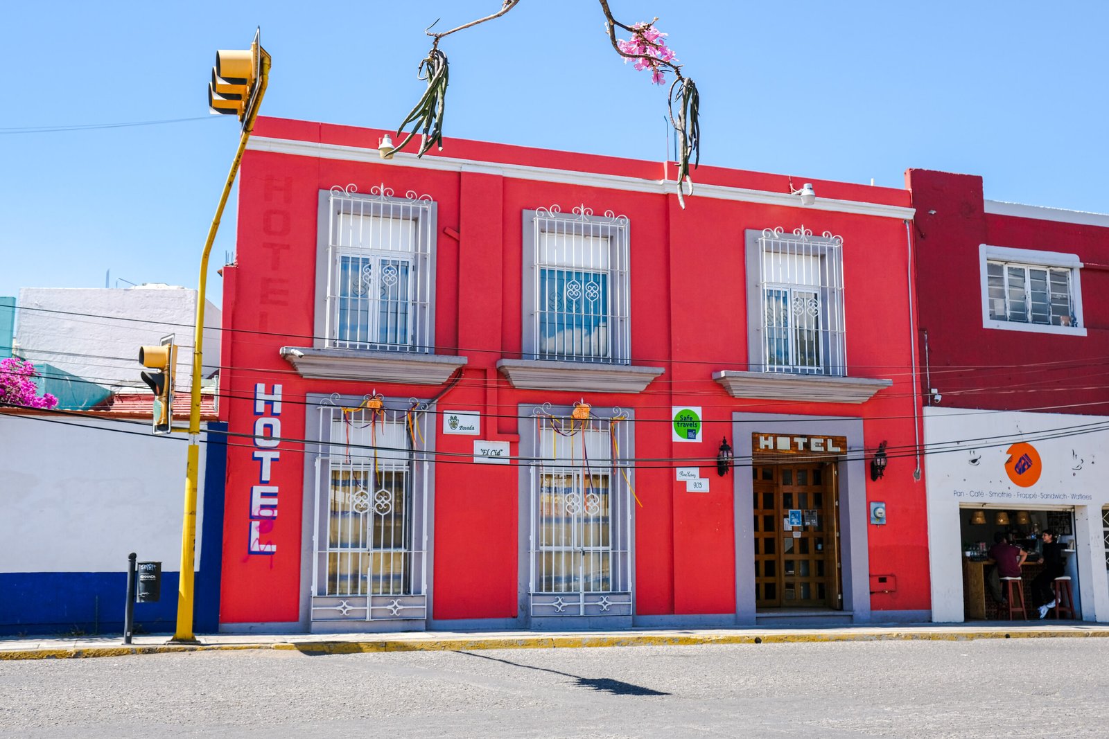 Fachada roja del Hotel Posada el Cid de día
